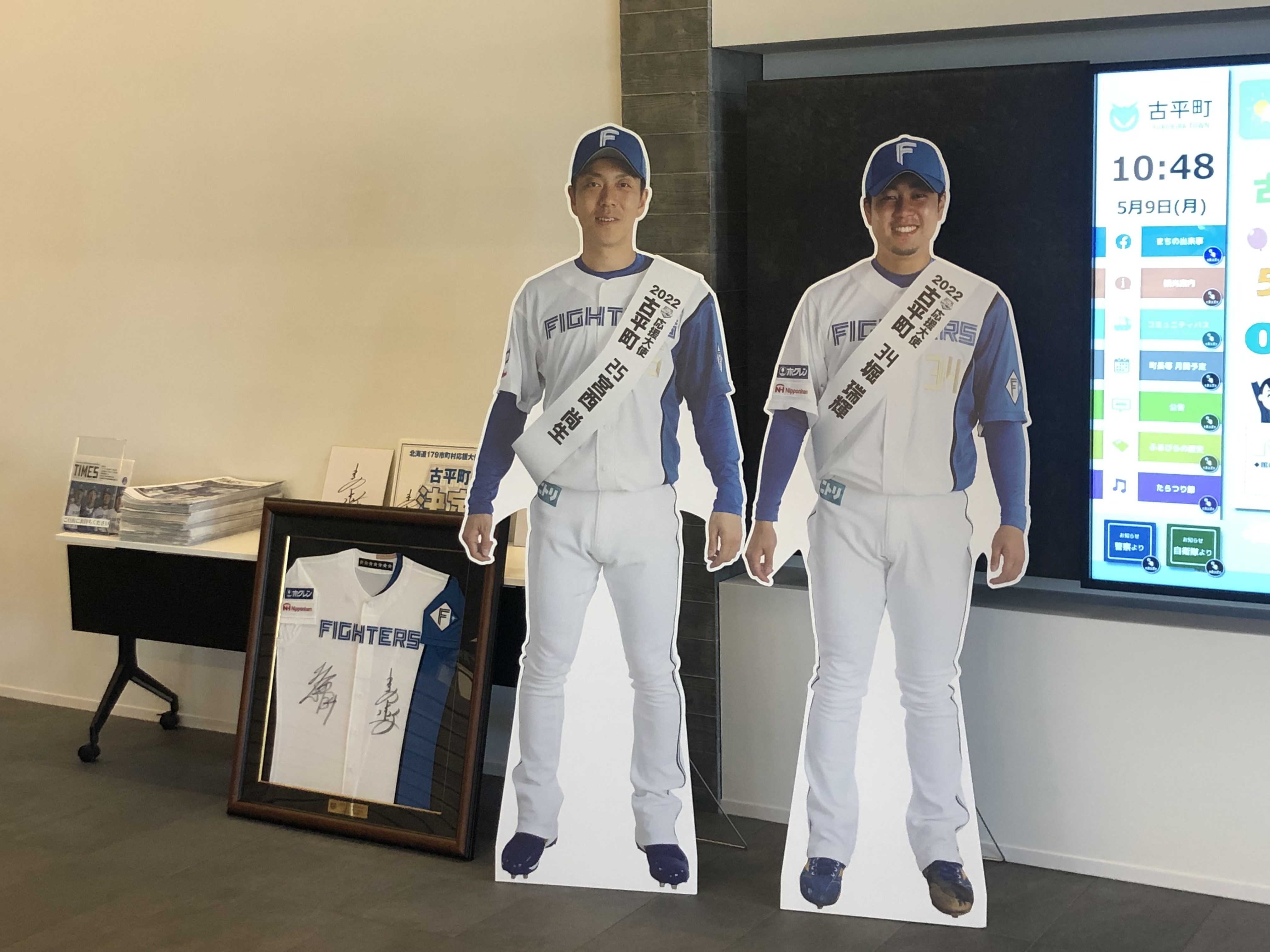宮西 尚生選手・堀 瑞輝選手の2022年古平町応援大使就任を記念いたしまして、古平町複合施設「かなえーる」内1Fロビーに特設コーナーを設置しました!
北海道日本ハムファイターズの最新情報をまとめた「ファイターズ・タイムズ」のほか、両選手の等身大パネルやサイン入りユニフォームなども置いています。
複合施設にお立ち寄りの際はぜひご覧になってください。